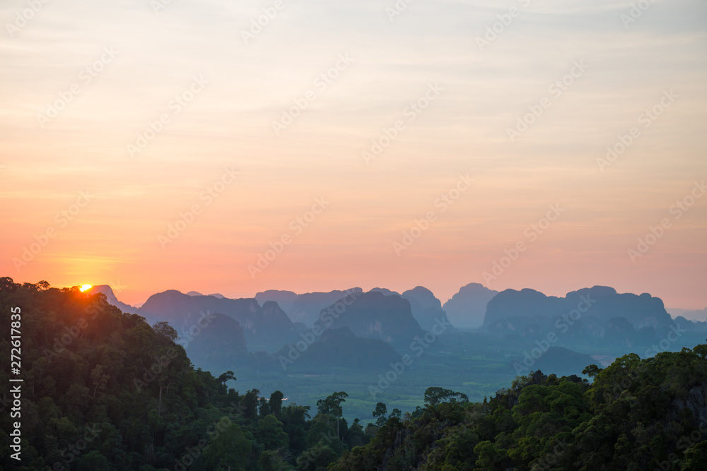 Beautiful landscape with dramatic sunset, tropical rainforest and steep mountain ridge on horizon. Krabi, Thailand