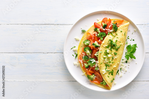 Stuffed omelette with tomatoes, red bell pepper and broccoli photo