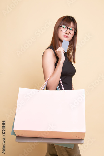 Young Asian woman with shopping bag and blank card.