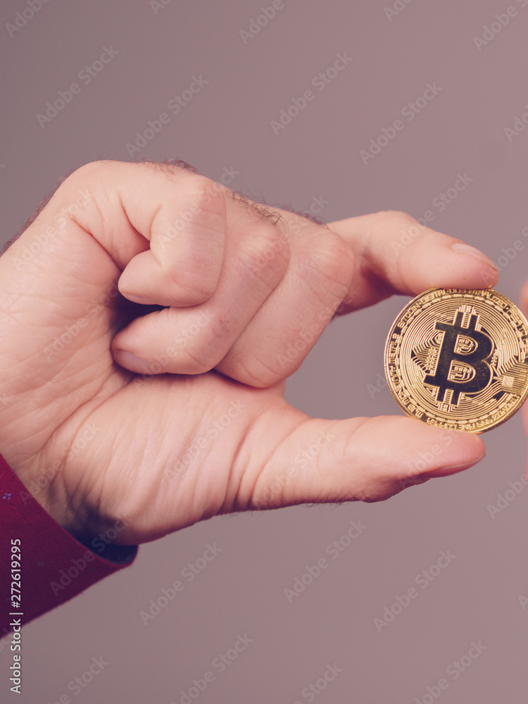 Man hand holding golden bitcoin Man hand holding golden bitcoin