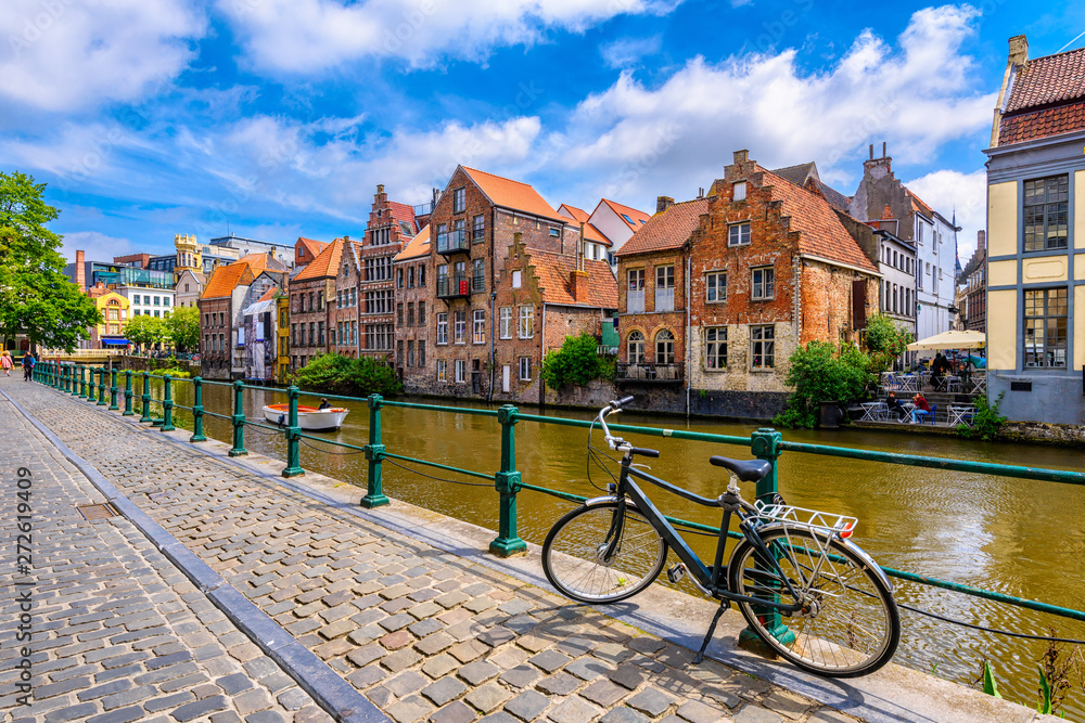 View of embankment of Leie river in the historic city center in Ghent (Gent), Belgium. Architecture and landmark of Ghent. Sunset cityscape of Ghent.