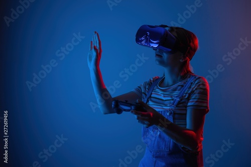 Young cute girl playing vr. with creative blue-red light. it is emeanantly and fun