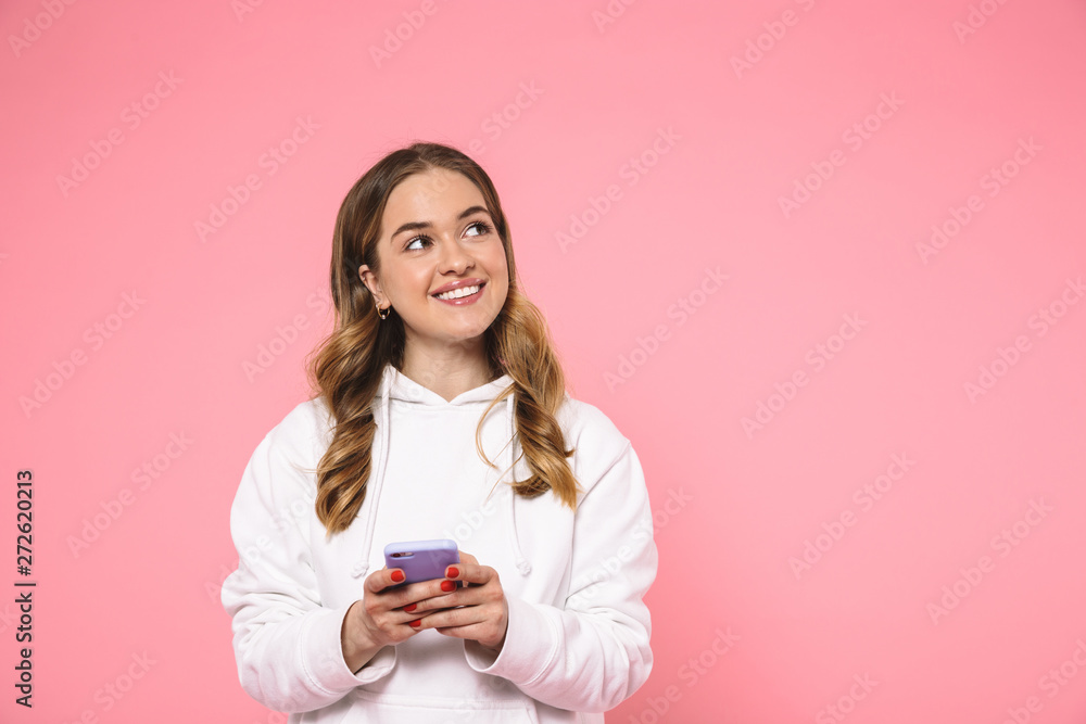 Smiling blonde woman wearing in casual clothes holding smartphone Smiling blonde woman wearing in casual clothes holding smartphone