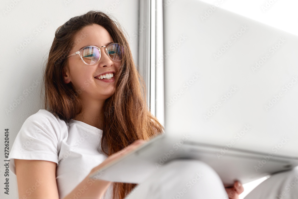 Cheerful young woman making video call on laptop Cheerful young woman making video call on laptop