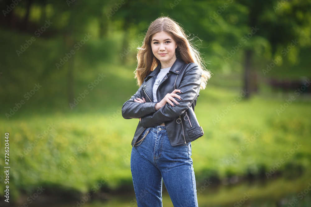 portrait of little beautiful stylish kid girl in city park on green forest background portrait of little beautiful stylish kid girl in city park on green forest background