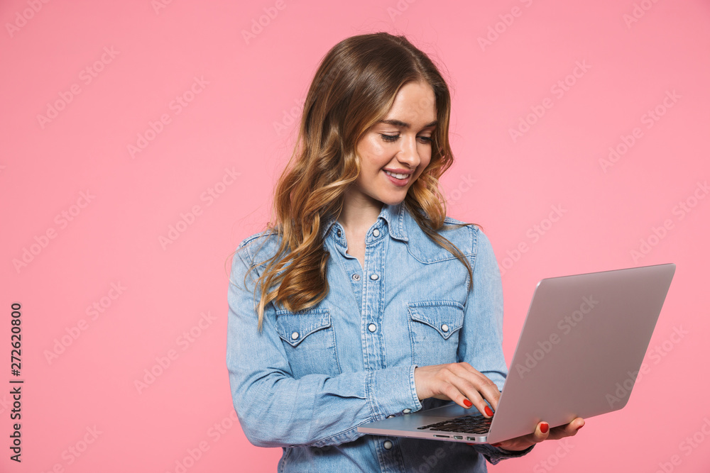 Smiling blonde woman wearing in denim shirt using laptop computer - obrazy, fototapety, plakaty 