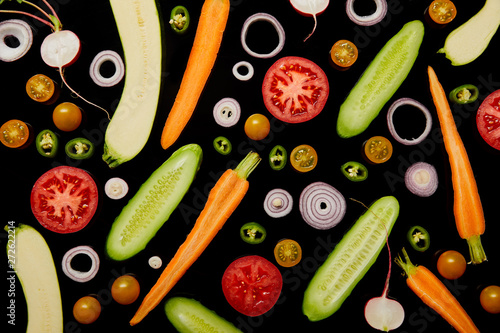 Fototapeta Naklejka Na Ścianę i Meble -  top view of fresh sliced vegetables isolated on black