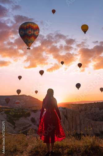 Anonymous female looking at hot air balloons