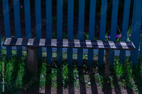Fototapeta Naklejka Na Ścianę i Meble -  blue fence,bench and striped shade on a Sunny summer day