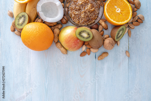 Healthy vegan raw foods on blue background. Fruits and nuts on the table. Organic sweet dessert. Place for text