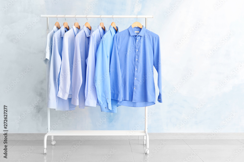 Rack with clothes after dry-cleaning near light wall Rack with clothes after dry-cleaning near light wall