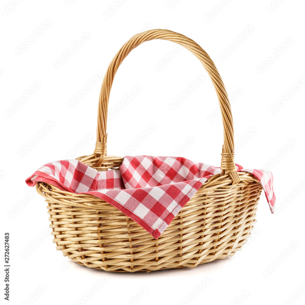 Empty wicker basket with red checkered tablecloth for picnic.