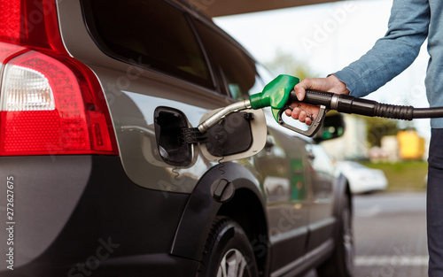 Принти на полотні Crop man refueling car on filling station