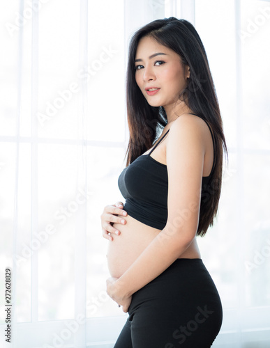 A beautiful pregnant woman stands to catch her stomach Free Download A beautiful pregnant woman stands to catch her stomach - GFXLoad