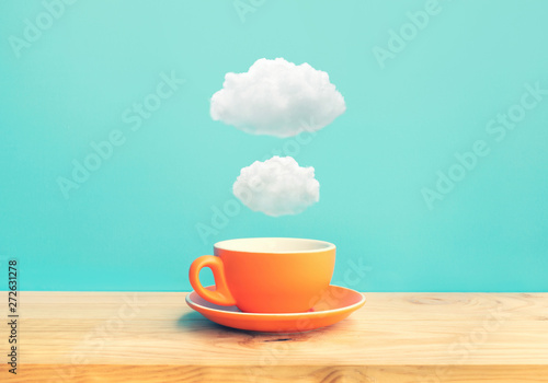 Inspiration creativity concepts with a cup of coffee on wood bar table with some cloud on blue sky color background