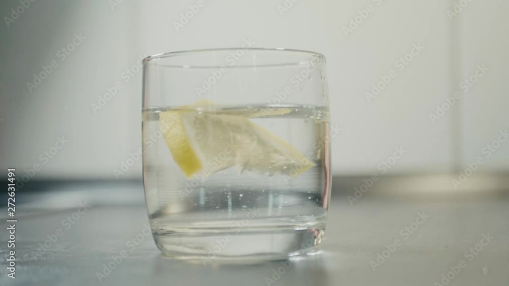 reverse lemon fall into a glass of water slow motion. reverse lemon fall into a glass of water slow motion.
