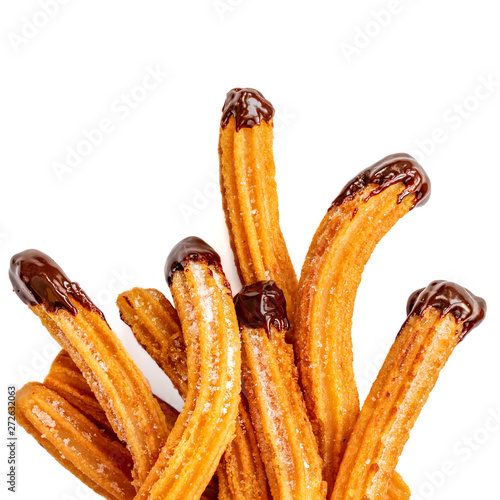 Churros - fried dough pastry with sugar and chocolate sauce dip isolated on a white background. Churro sticks, traditional Spanish snack. photo