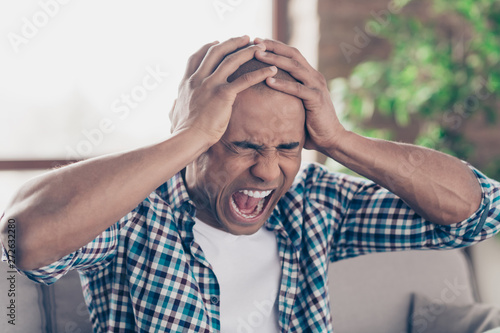 Close up photo of disappointed millennial crazy wild aggressive scandal touch head hand palm shout dressed shirt plaid fashionable big apartment room 