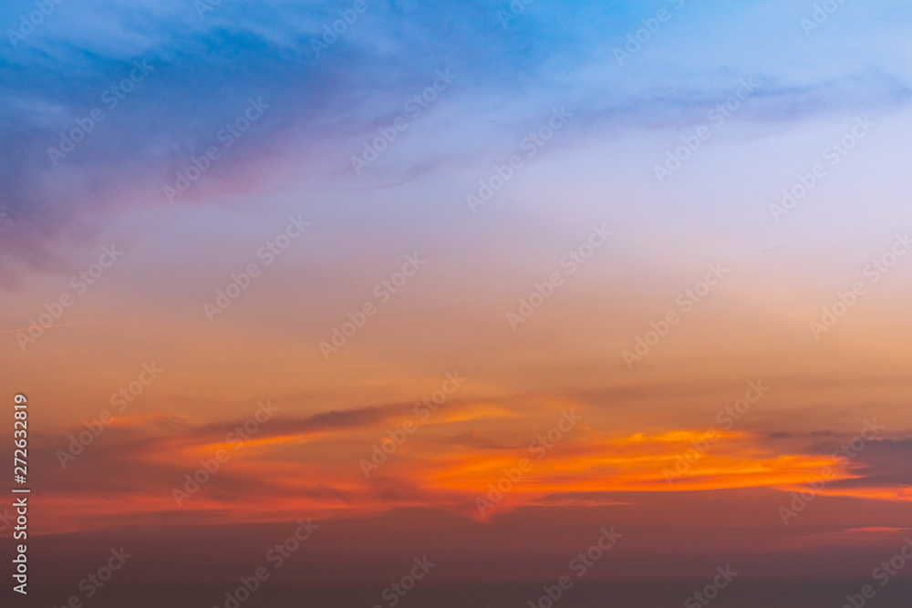 Dramatic blue and orange sky and clouds abstract background. Red-orange clouds on sunset sky. Warm weather background. Art picture of sky at dusk. Sunset abstract background. Dusk and dawn concept