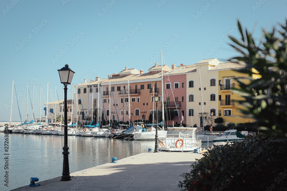 A street lamp with a background of colorful houses and boats at Saplaya Port Alboraya Valencia Spain