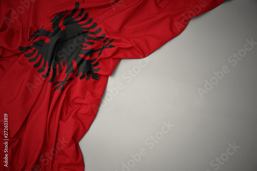 waving national flag of albania on a gray background.