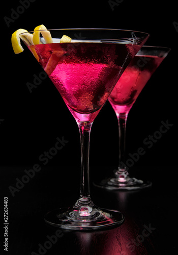 Pink cosmopolitan cocktails isolated on black