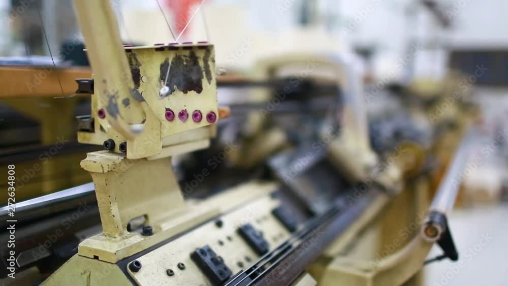 Close up and selective focus to machine. Textile factory in spinning production line and a rotating machinery and equipment production company. Weaving and warping. Elastic weaving workshop. Close up and selective focus to machine. Textile factory in spinning production line and a rotating machinery and equipment production company. Weaving and warping. Elastic weaving workshop.