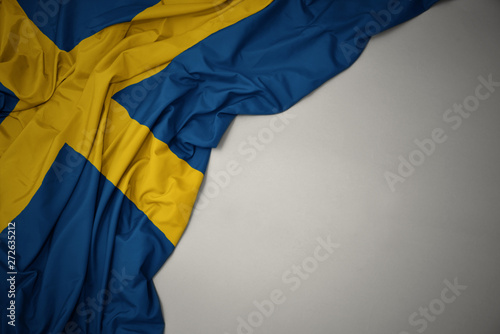 Photography waving national flag of sweden on a gray background.