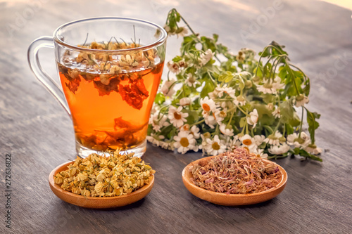 Herbal tea with pharmaceutical chamomile and dry chrysanthemum on a gray wooden table