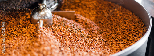 Fotografija Freshly roasted coffee beans from a large roaster in the cooling cylinder
