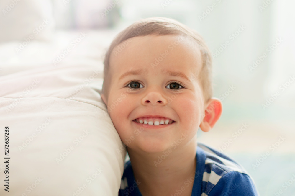 2 year old boy in a white light room in the morning smiling