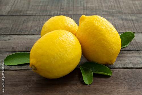 fresh lemon with leaves on wood background