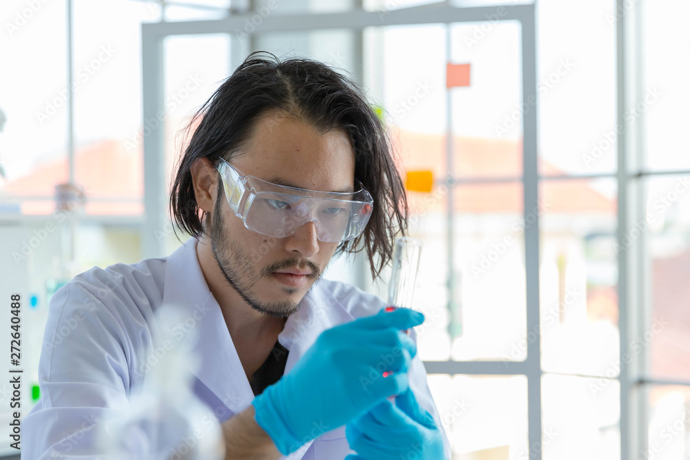 The Asian smart man scientist is testing test tube. The Asian smart man scientist is testing test tube.