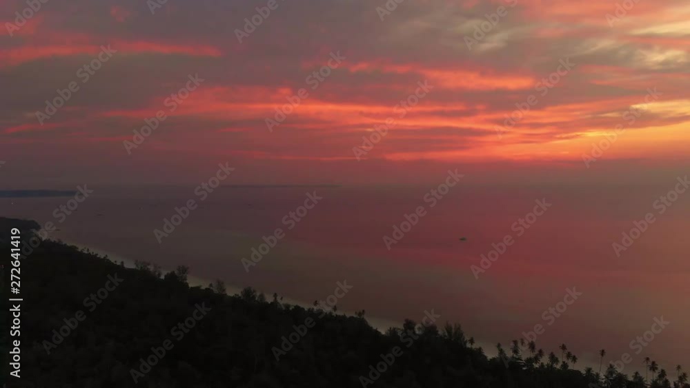 Aerial: colorful sunset dramatic sky over tropical sea at Pasir Panjang Kei Islands Maluku Moluccas Indonesia scenic travel destination Aerial: colorful sunset dramatic sky over tropical sea at Pasir Panjang Kei Islands Maluku Moluccas Indonesia scenic travel destination