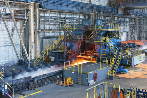 machine with conveyor belt with glowing metal frame in the production line of a steel mill