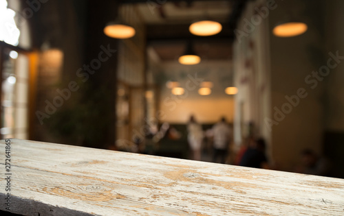 image of wooden table in front of abstract blurred background of resturant lights