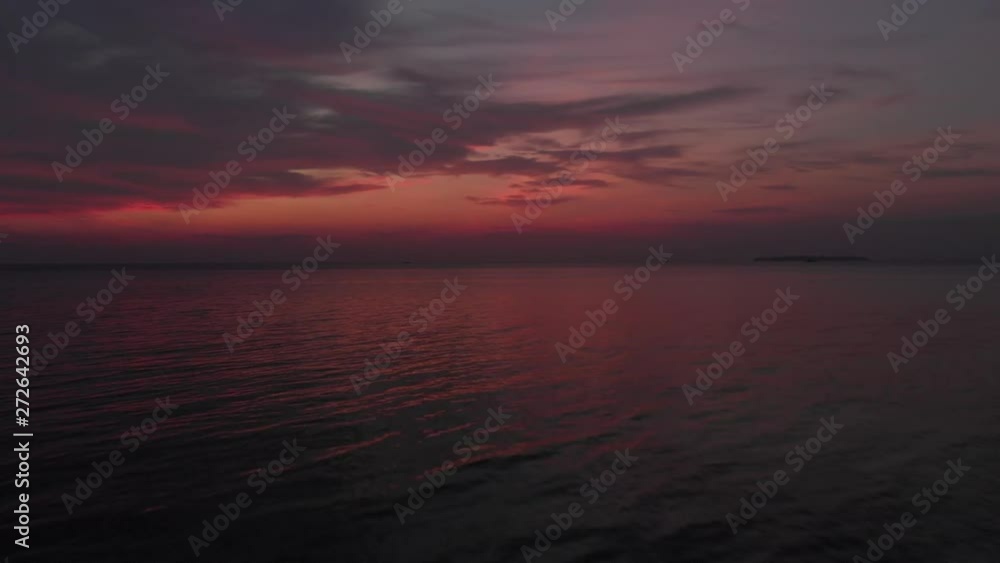 Aerial: colorful sunset dramatic sky over tropical sea at Pasir Panjang Kei Islands Maluku Moluccas Indonesia scenic travel destination. Native cinelike D-log color profile Aerial: colorful sunset dramatic sky over tropical sea at Pasir Panjang Kei Islands Maluku Moluccas Indonesia scenic travel destination. Native cinelike D-log color profile