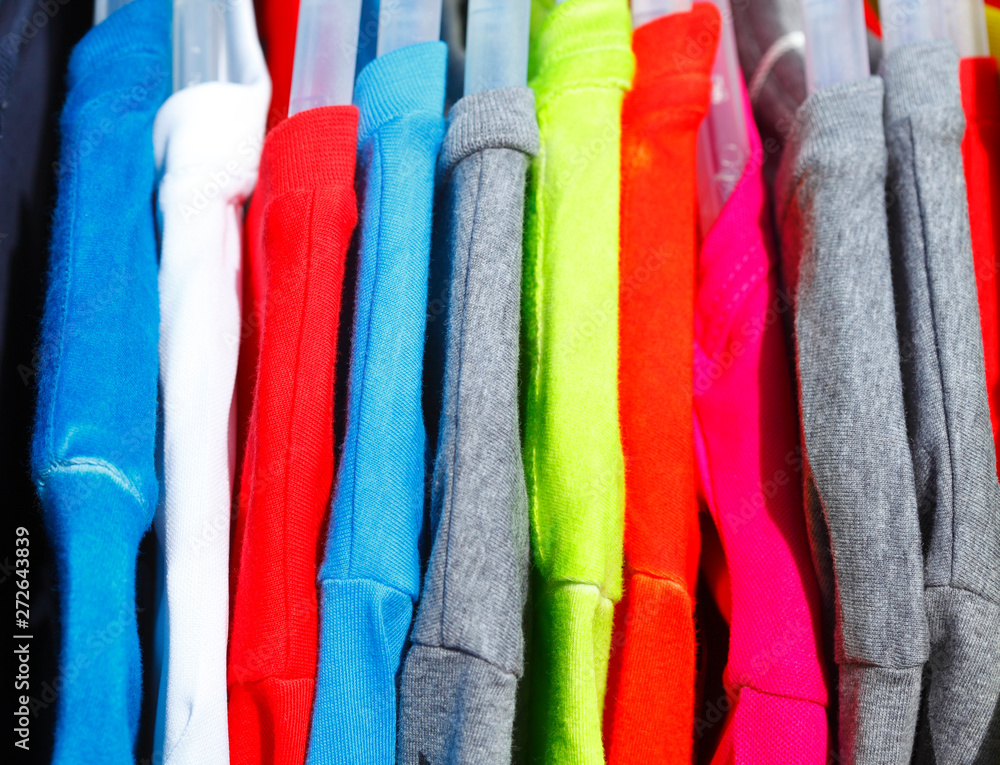 Bunte T-Shirts auf Kleiderbügeln Bunte T-Shirts auf Kleiderbügeln