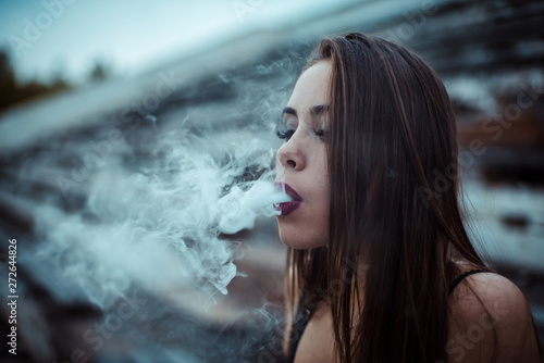 Fototapeta Naklejka Na Ścianę i Meble -  young sexy vaping vaponizers and clouding, girls with sexy bodie
