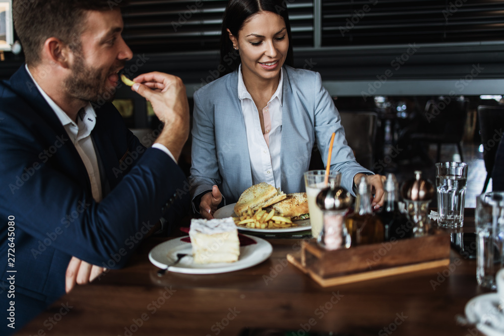 Happy couple man and woman sitting and eating in modern cafe bar or restaurant. Happy couple man and woman sitting and eating in modern cafe bar or restaurant.