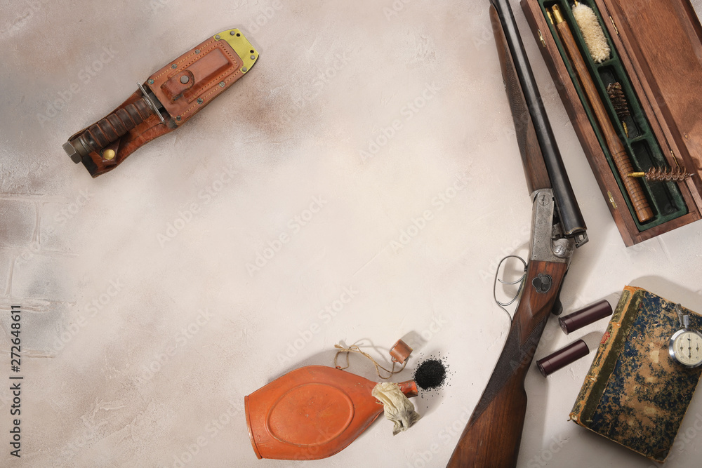 Hunting concept with shotgun, knife and ammunition for hunting arranged on light background.Wildfowl hunting.