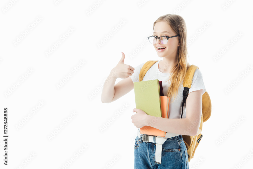 smiling schoolgirl with backpack holding books and showing thumb up isolated on white smiling schoolgirl with backpack holding books and showing thumb up isolated on white