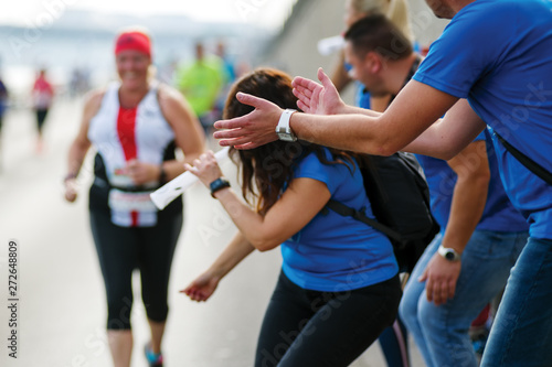 Fans group cheering up a marathon runner photo