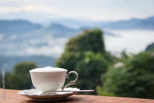 Coffee in white cup at the morning time have mountain background