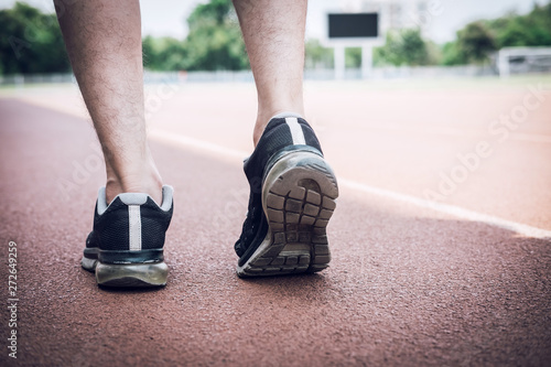 Runner feet of athlete running on road track, exercise jog workout wellness concept