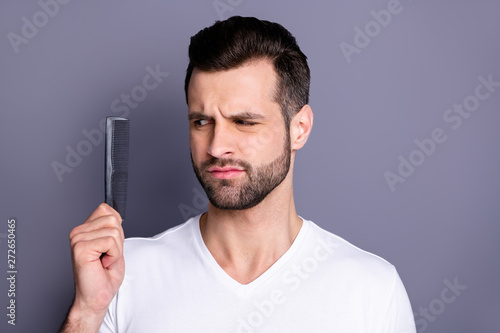 Close up photo amazing he him his macho deny not sure action new hand arm plastic hair styling brush take care hairdo after barber shop stylist visit wear casual white t-shirt isolated grey background