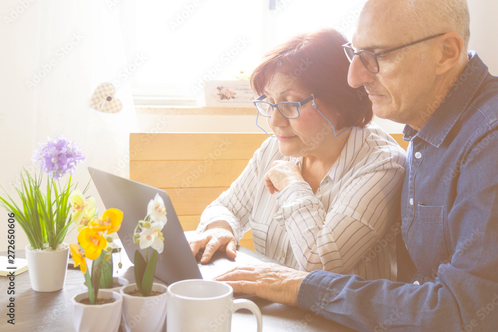 A middle aged couples enjoy the laptop by shopping online and reading news A middle aged couples enjoy the laptop by shopping online and reading news