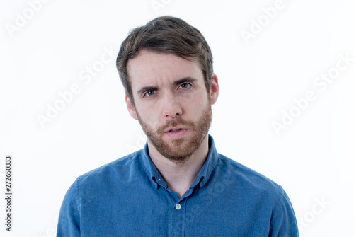 Portrait of young man with angry face looking furious. Human expressions and emotions