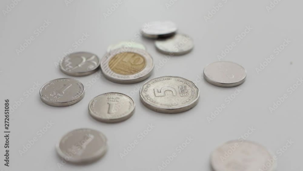 Camera pulls out revealing different Israeli coins set on white background Camera pulls out revealing different Israeli coins set on white background