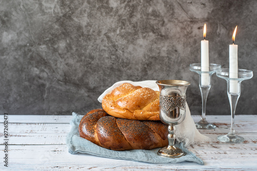 Foto Shabbat Shalom - challah bread, shabbat wine and candles on grey background